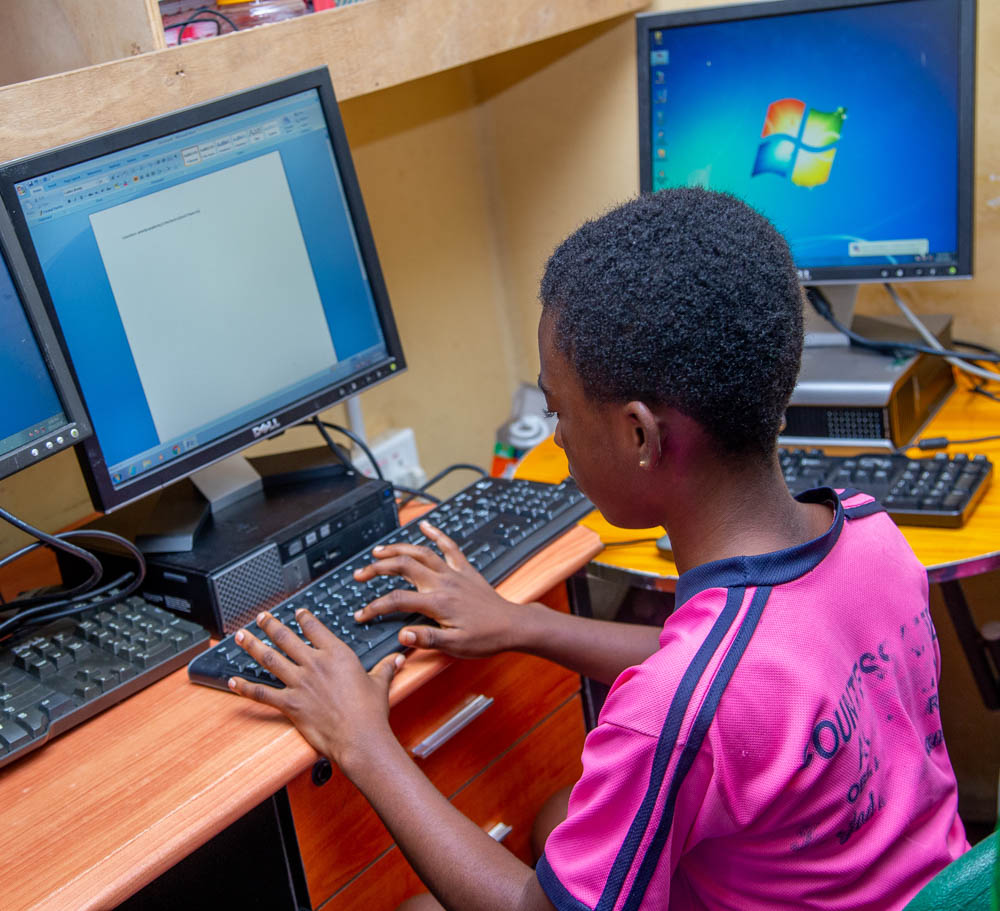 A student using a computer donated by smileatschool